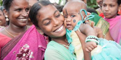 Annandhi holds a baby, smiling