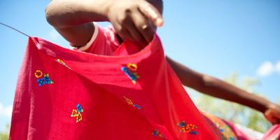 A girl hangs clothes on a clothes line