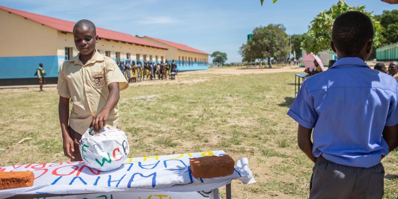 Boy voting, a voting queue can be seen behind him