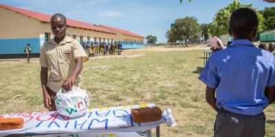 Boy voting, a voting queue can be seen behind him