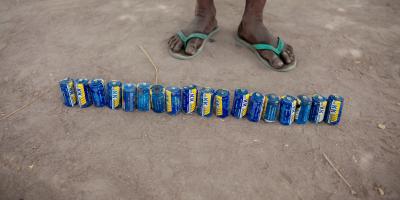 Line of cans in front of a pair of feet
