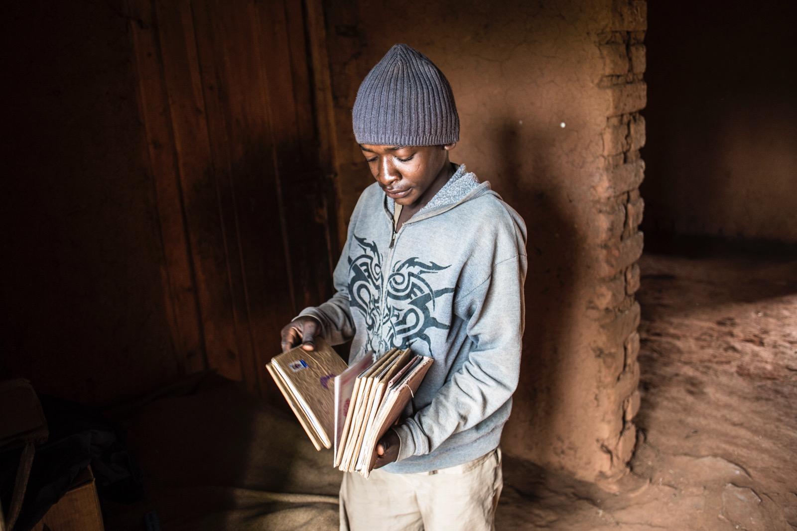A young boy holding some letters.