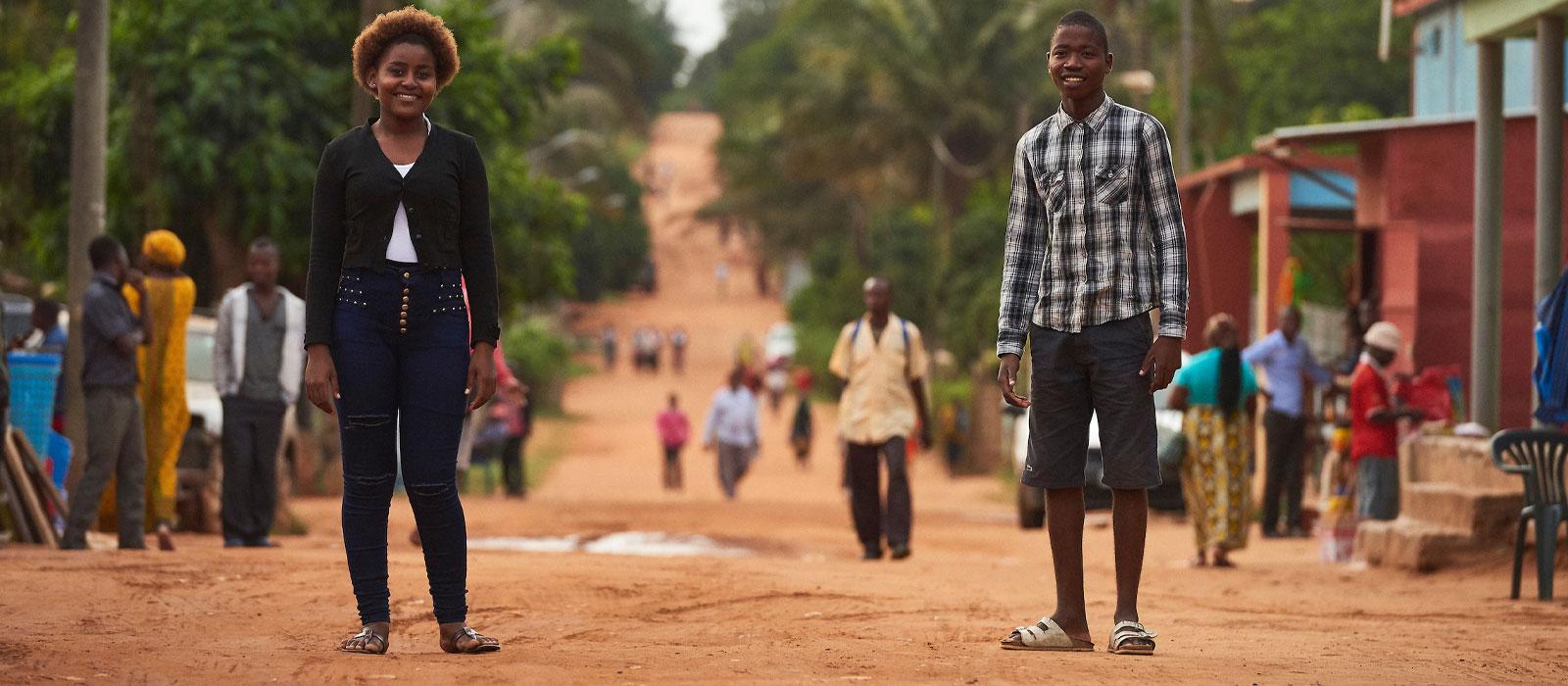 A girl and boy standing on village road. 