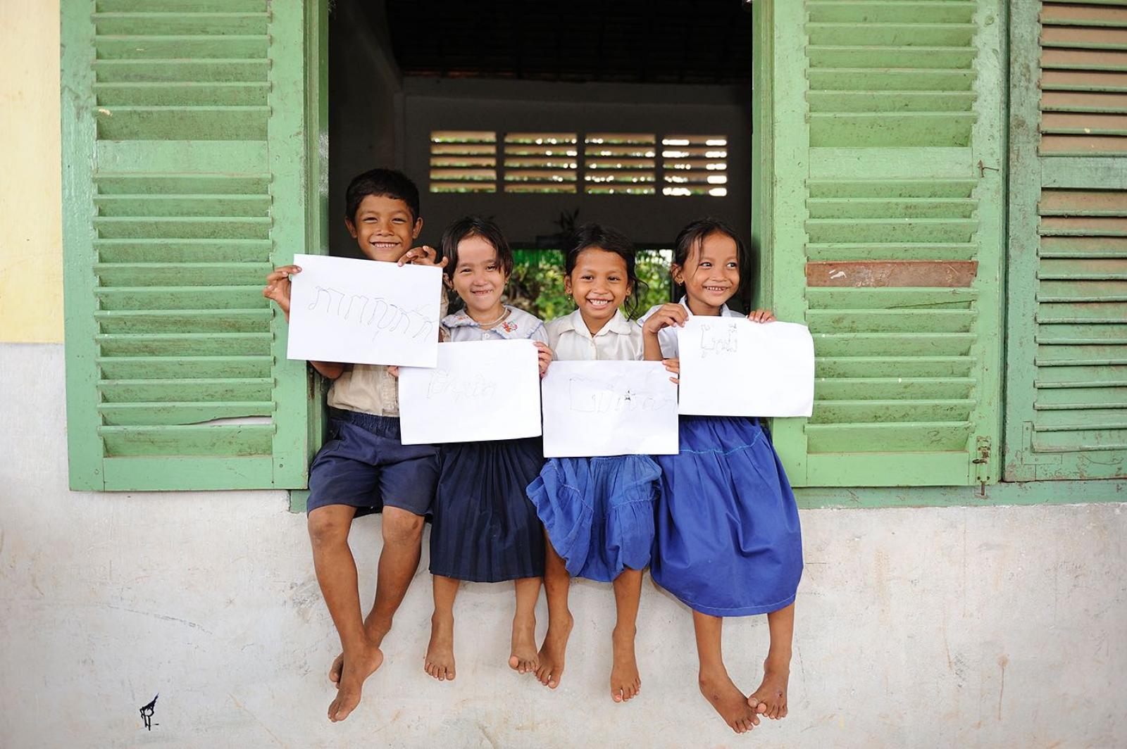 Children learning to read shows how they have written their names.