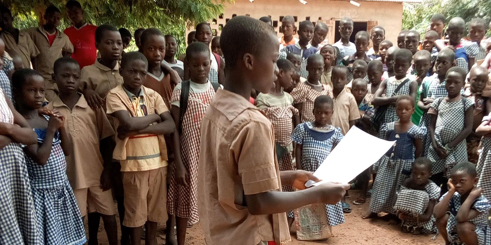 Boy talking to large group of children