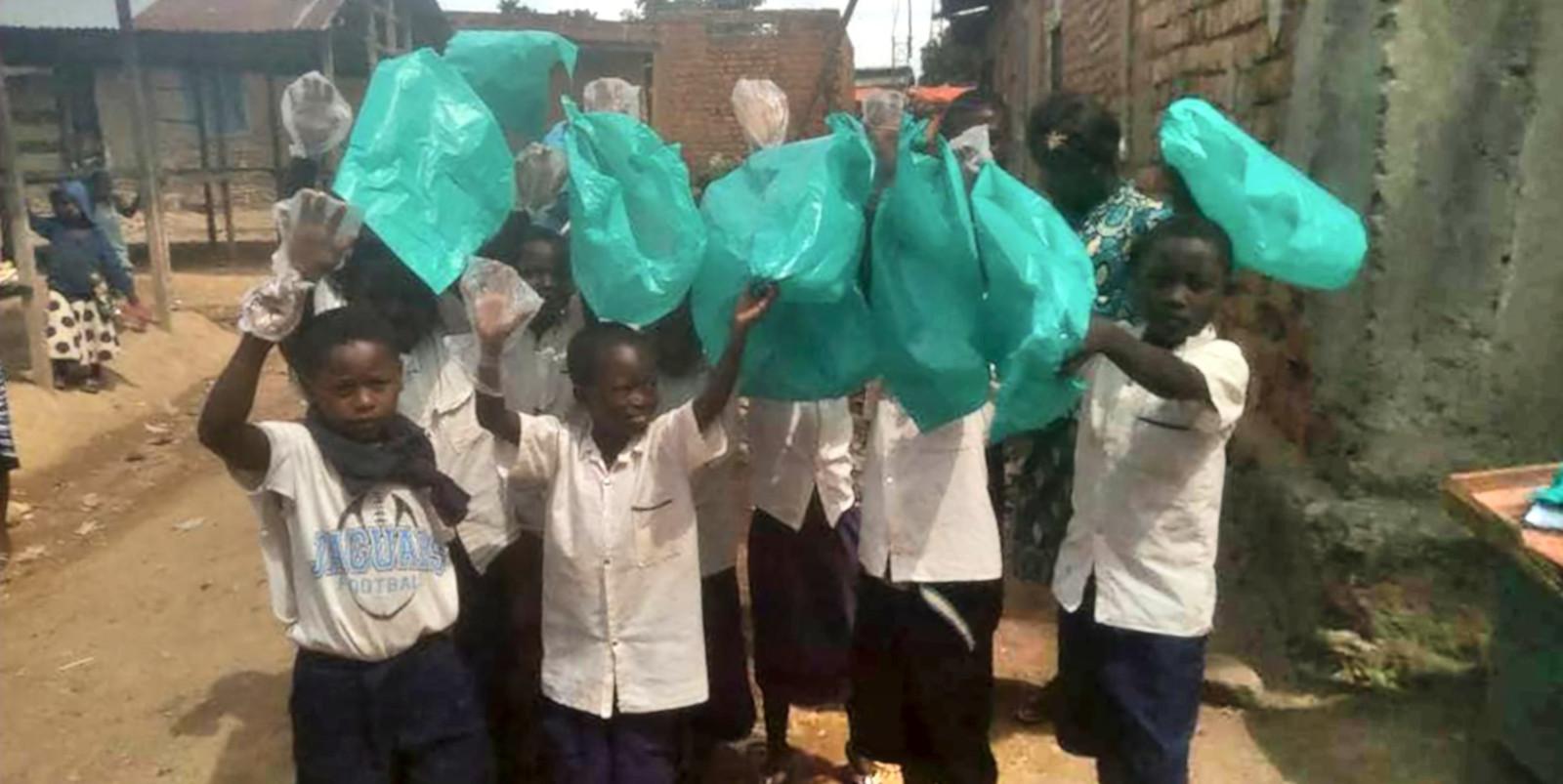 Children carrying empty plastic bags, walking towards the camera