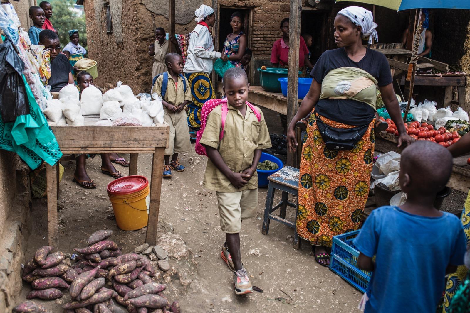A young boy walking through a market.