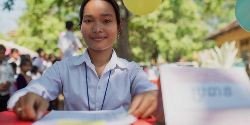 Girl checking voting register on Global Vote Day