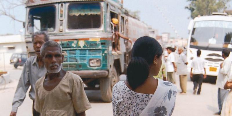 Girl watching people and traffic on busy street. 
