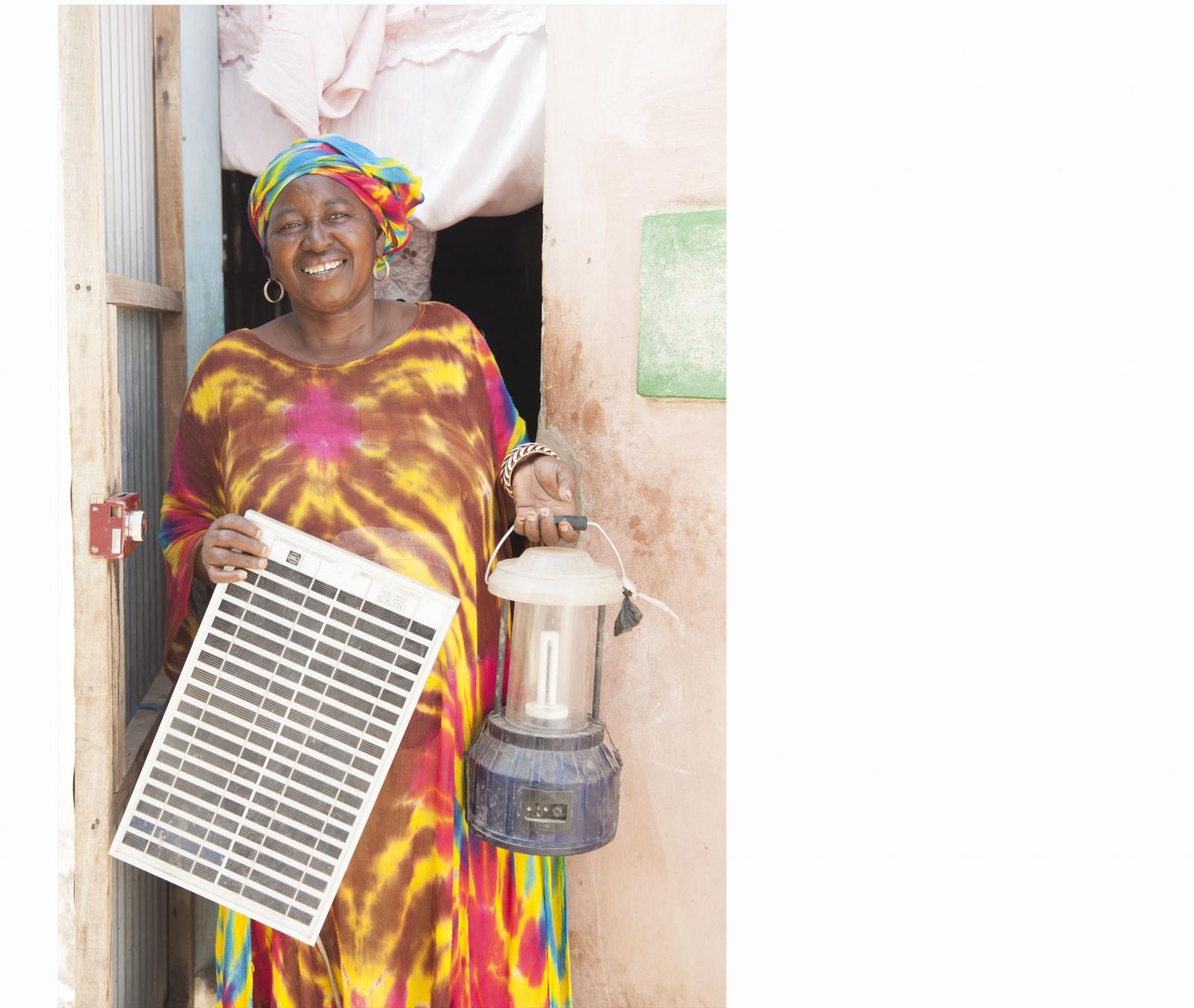 Grandma holds a solar panel and a lantern.