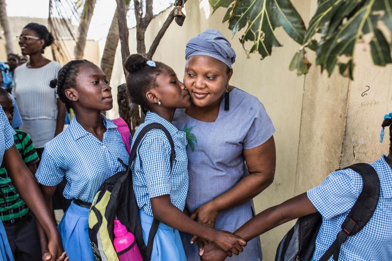 Guylande getting a kiss on the cheek by a young girl
