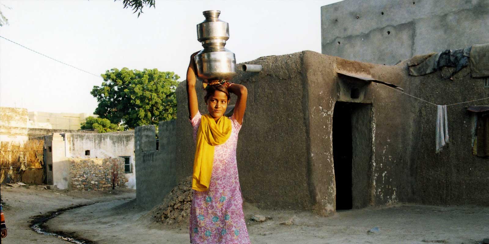 a woman holding a vase on her head