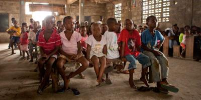 children sitting in big hall