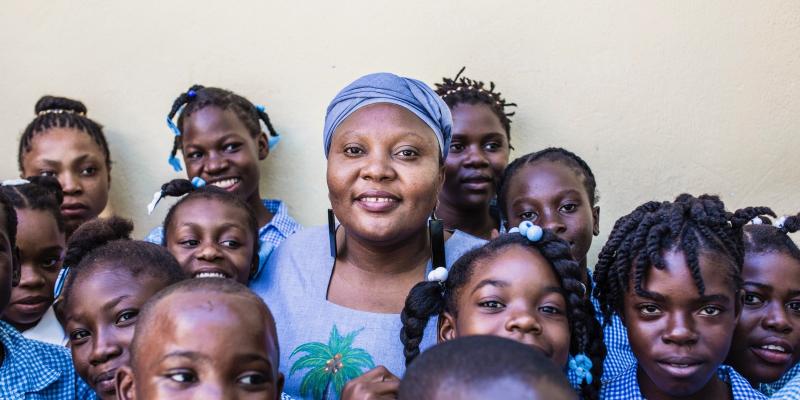 Guylande posing with some children.