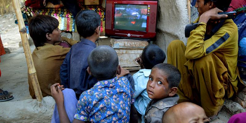 Boys watching TV outside
