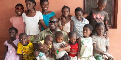 Manuel Rodrigues sits with blind children