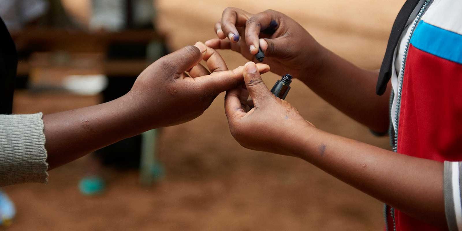 a pair of childhands marking another pair with ink 