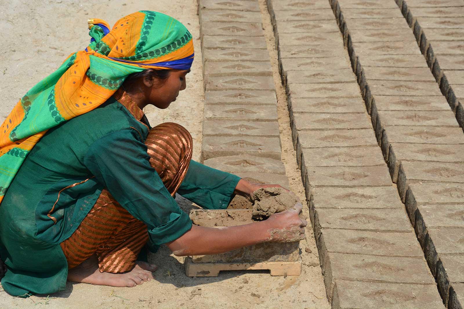 Nisha making bricks under bright sunlight