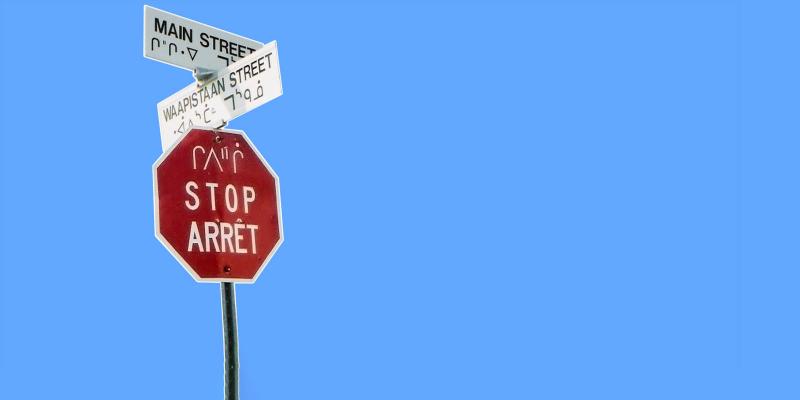 Red stop-sign in hthree languages, cree, english and french.