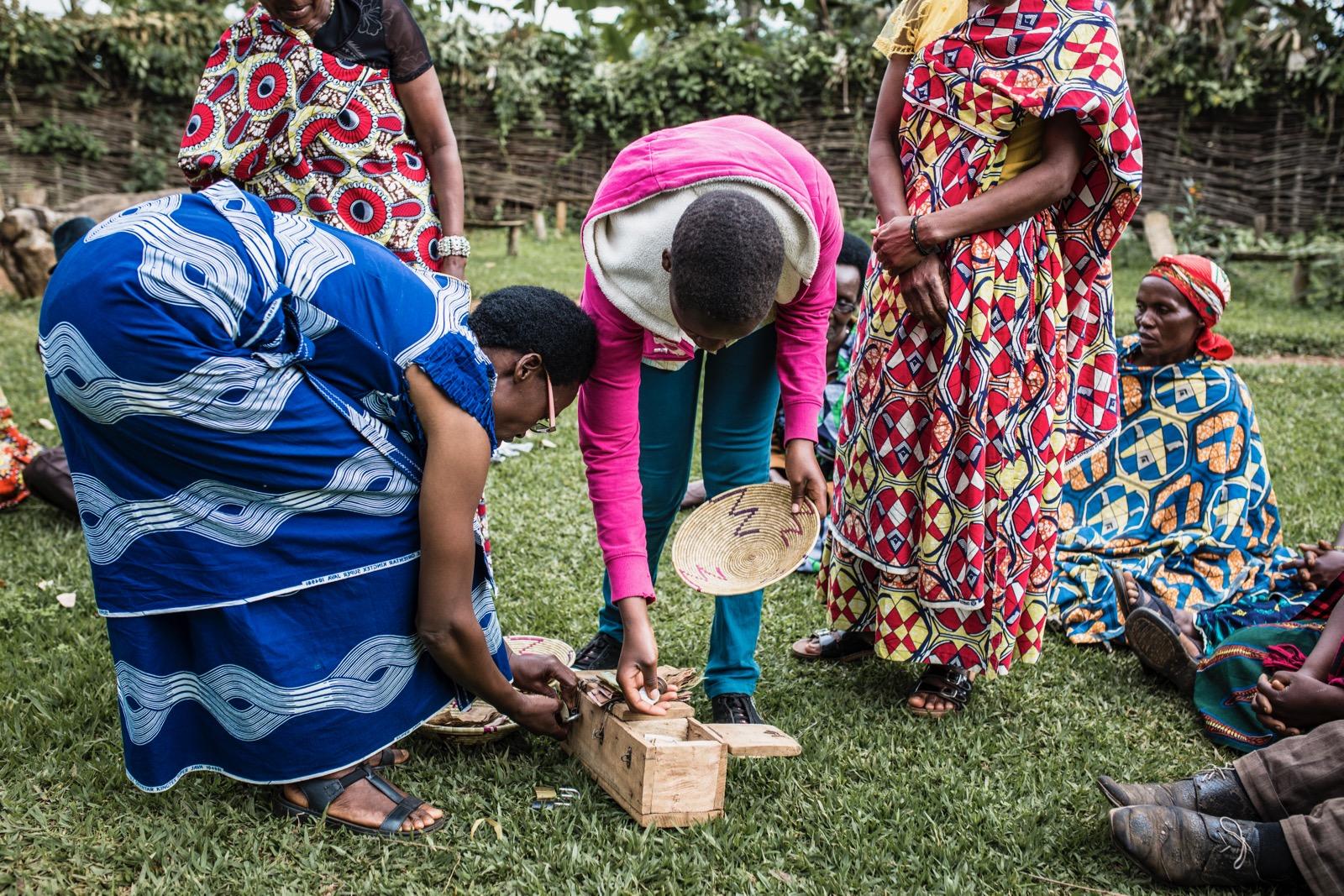 Two people handling a wooden box.