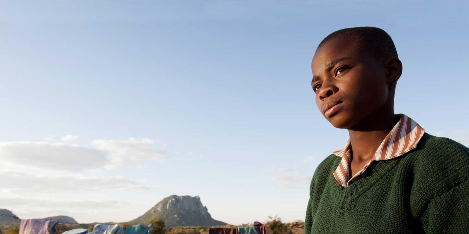 Takudza standing outside looking serious