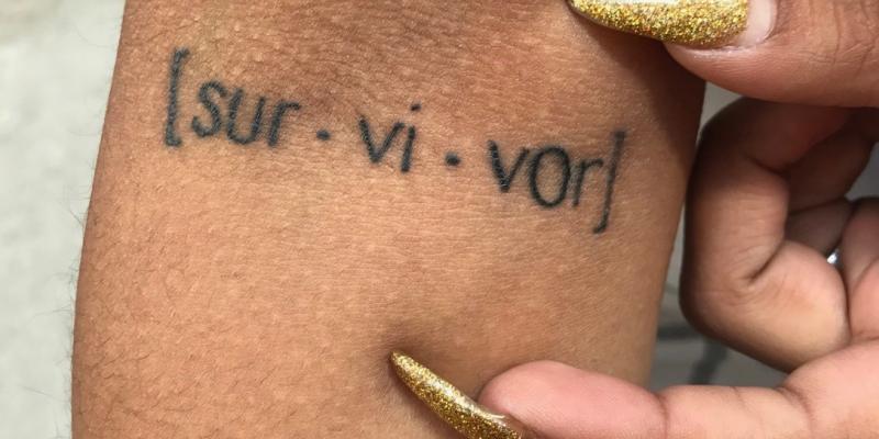 Tattoo on arm reading Survivor
